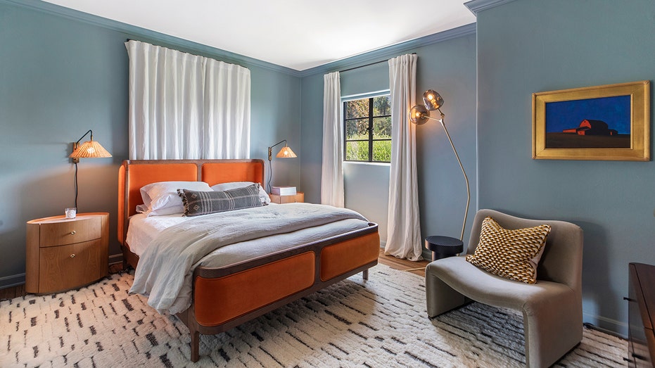 One of the bedrooms features blue walls and an orange bed.