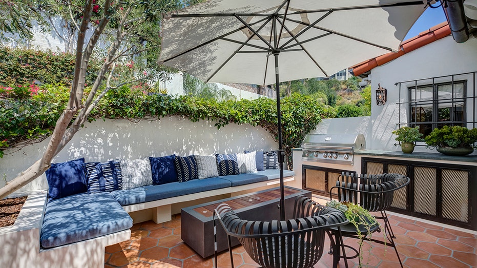 The kitchen opens onto the front patio with a barbecue and seating around a fire pit.