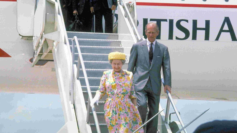 The queen and Prince Philip stepping off an airplane