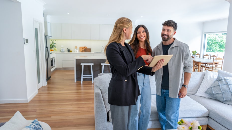 A realtor showing a home to a couple