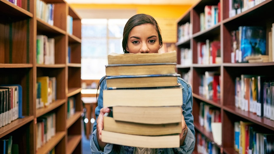 Woman holding textbooks in library