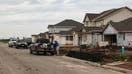 Workers in front of homes under construction in Kyle, Texas, US, on Monday, March 18, 2024. The US Census Bureau is scheduled to release housing starts figures on March 19. 