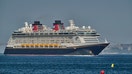 Disney Dream, a 129,690 GT cruise ship operated by Disney Cruise Line, part of The Walt Disney Company, sails the Tagus River in a summer afternoon after leaving Lisbon cruise terminal on July 18, 2023 in Oeiras, Portugal.