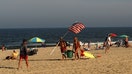 SPRING LAKE, NJ - JULY 6: Lifeguards carry their gear and an American flag as they leave the beach at the end of their day on July 6, 2023, in Spring Lake, New Jersey. (Photo by Gary Hershorn/Getty Images)
