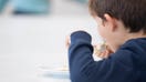 10 December 2019, Baden-Wuerttemberg, Stuttgart: A boy eats a pancake during lunch in the canteen of a primary school. Photo: Sebastian Gollnow/dpa (Photo by Sebastian Gollnow/picture alliance via Getty Images)