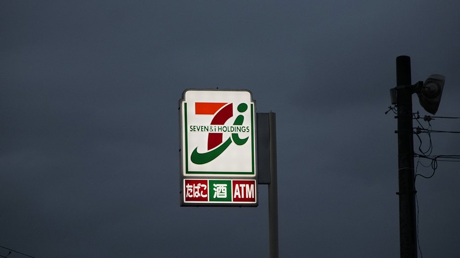 An illuminated logo at a 7-Eleven convenience store, operated by Seven & i Holdings Co., in Kobe, Japan, on Friday, Aug. 30, 2024. Alimentation Couche-Tard Inc. had made a preliminary non-binding proposal to buy Seven & i, which operates more than 85,000 stores across the globe, and the deal would be the biggest-ever foreign takeover of a Japanese company. Photographer: Soichiro Koriyama/Bloomberg via Getty Images