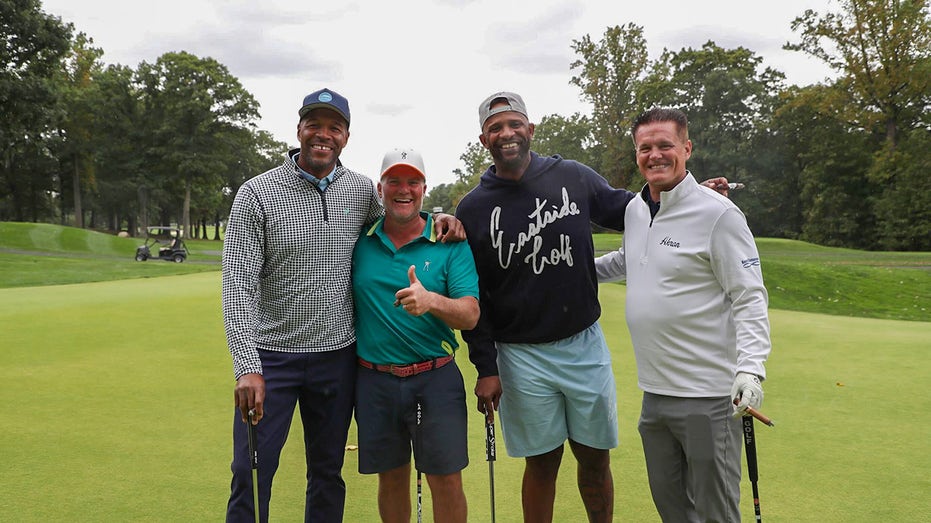 Michael Strahan, Tim Clepper, CC Sabathia and Matt Kaulig smile on the golf course