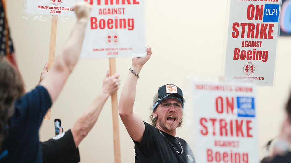 Een Boeing-werknemer steekt zijn vuist op tijdens een vakbondsstaking