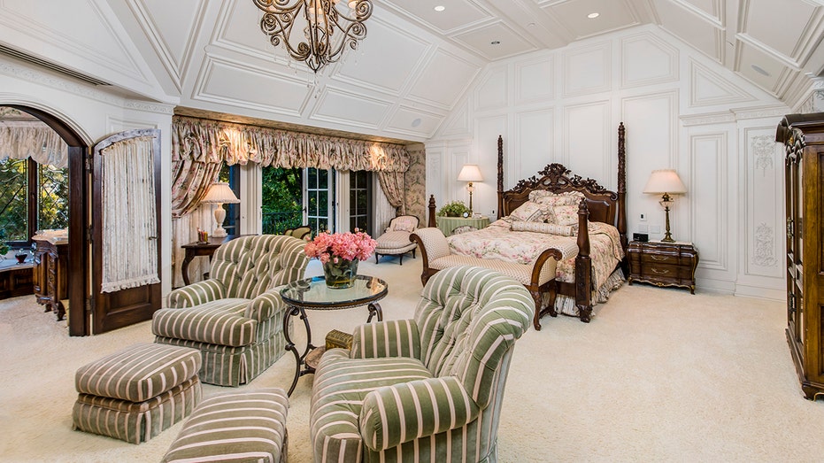 the master bedroom with two green striped chairs