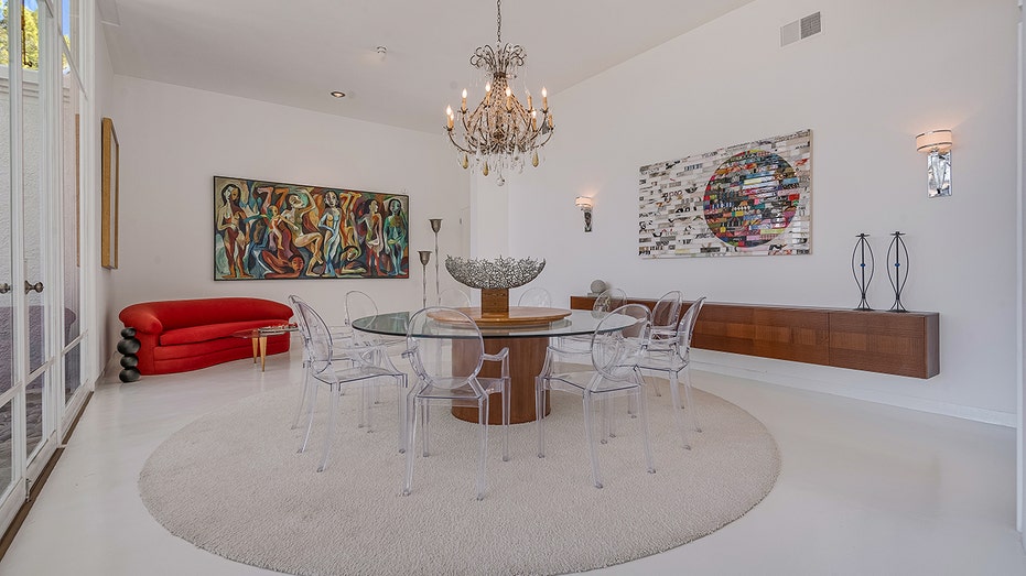 The dining room features a circular table big enough for 10 and art on the walls.