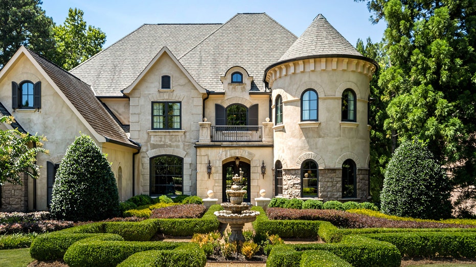 The front of Kenny Rogers' home features boxwood hedges and a fountain.