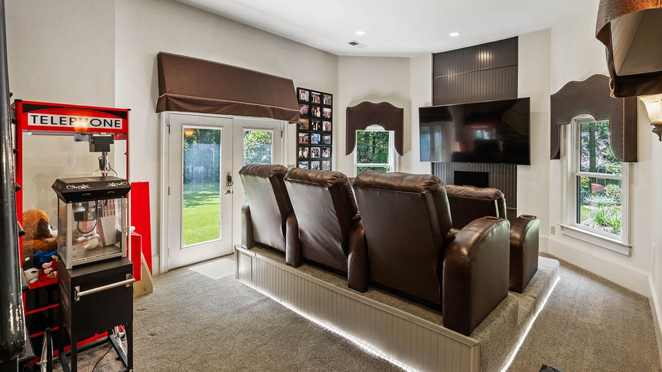 The media room features theater-style layered seating and a flat-screen TV.