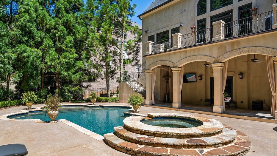 The backyard features a pool and a covered patio area.