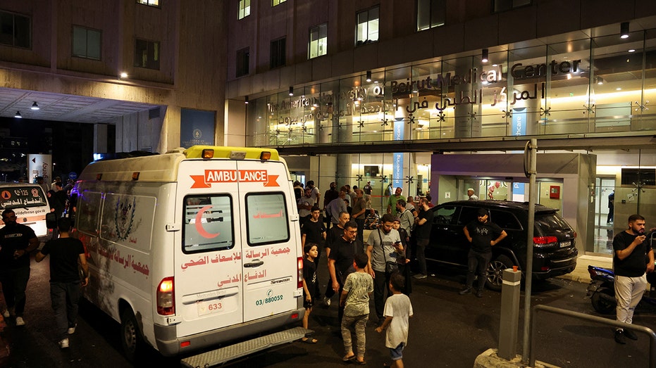 People walk near an ambulance