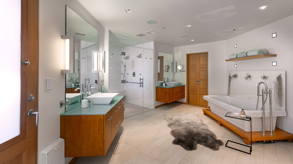 The first bathroom consists of two vanities, a standing shower and a soaking tub.