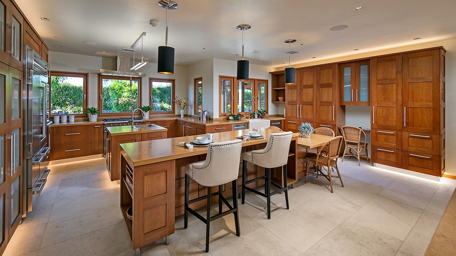 The kitchen has a center island, double sinks, double over and wine fridge. 