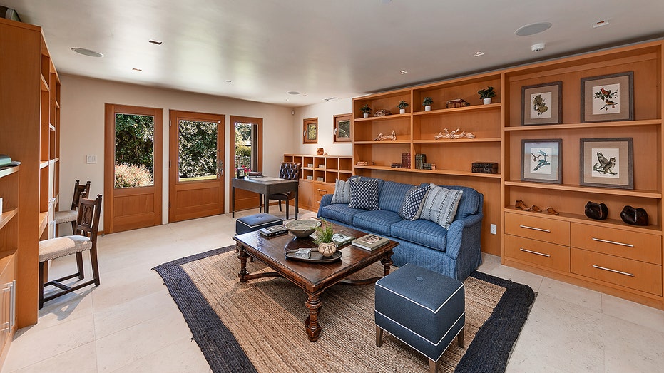 The office space has shelves and plenty of space for multiple desks.