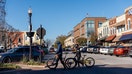 Pedestrians with bicycles at the main downtown square in Bentonville, Arkansas, US, on Monday, Nov. 21, 2022. In the spring of 2022, Walmart Inc. created a new position, called director of workplace mobility, with a very specific task: Figure out how to get 10% of the retailer&apos;s local workforce to commute by any means other than driving alone. Photographer: Terra Fondriest/Bloomberg via Getty Images
