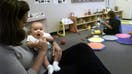 Adria Taha, an assistant director of Camp Amgen holds 4 month old Carter Noda in one of the infant rooms at Camp Amgen, the largest day care center in the country . It is at Amgen in Thousand Oaks. 