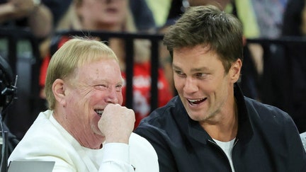 Las Vegas Raiders owner and managing general partner and Las Vegas Aces owner Mark Davis (L) and Tom Brady laugh as they attend Game One of the 2023 WNBA Playoffs finals between the Aces and the New York Liberty at Michelob ULTRA Arena on October 08, 2023 in Las Vegas, Nevada. 