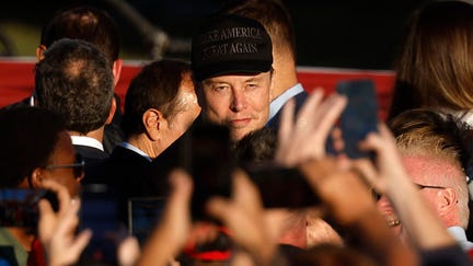 Elon Musk dons a black "Make America Great Again" ball cap during a campaign rally for former President Donald Trump in Butler, Pennsylvania.