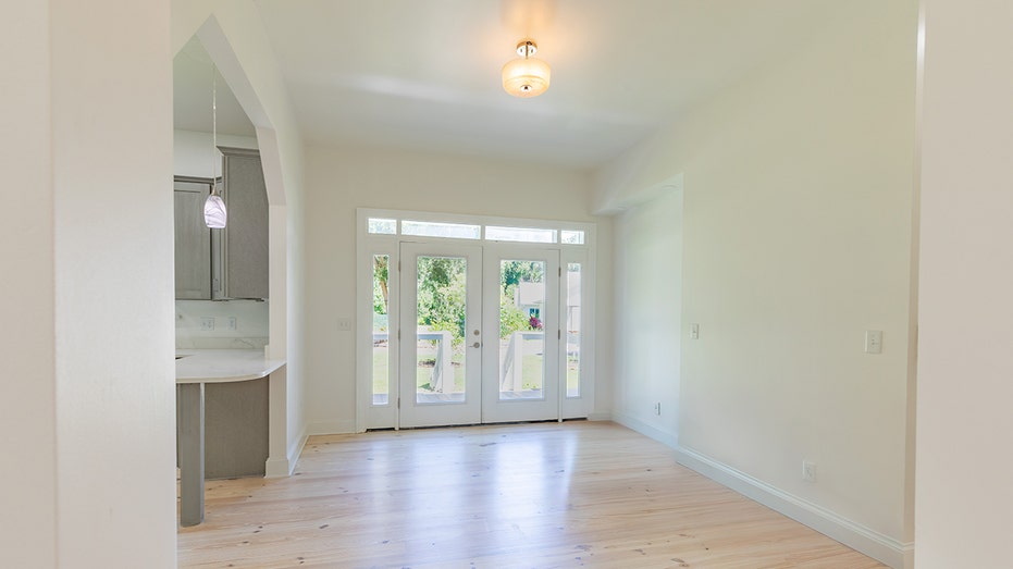 The entryway to the guest house leads to a living room and has access to the kitchen via an archway.