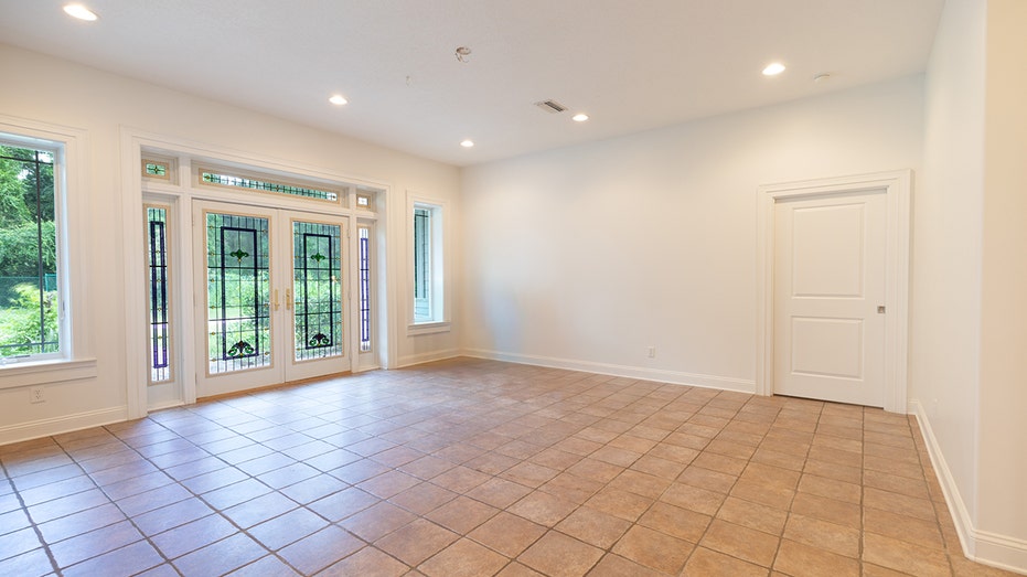 The living room is accessed through stained-glass double French doors.