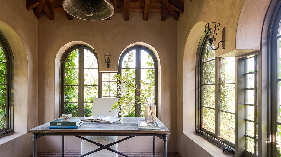 Windowed office, with old bell, wooden ceiling and brick floor.