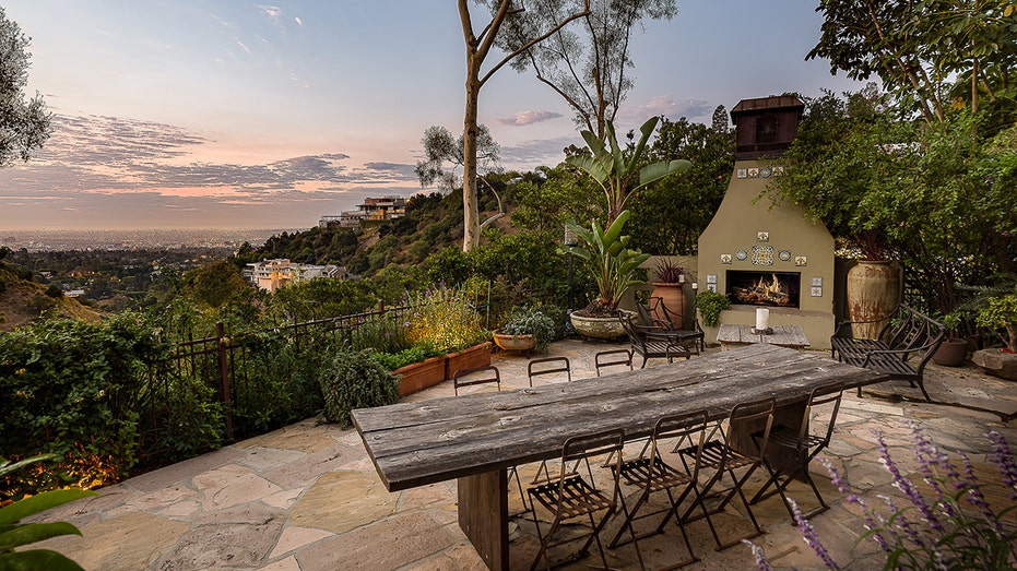 The patio boasts views of the valley below and has an outdoor fireplace.