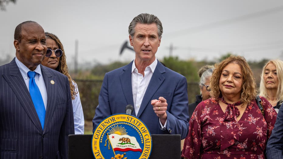 California Gov. Gavin Newsom at lectern with other officials