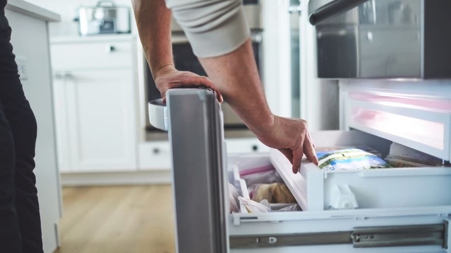 Woman checking freezer