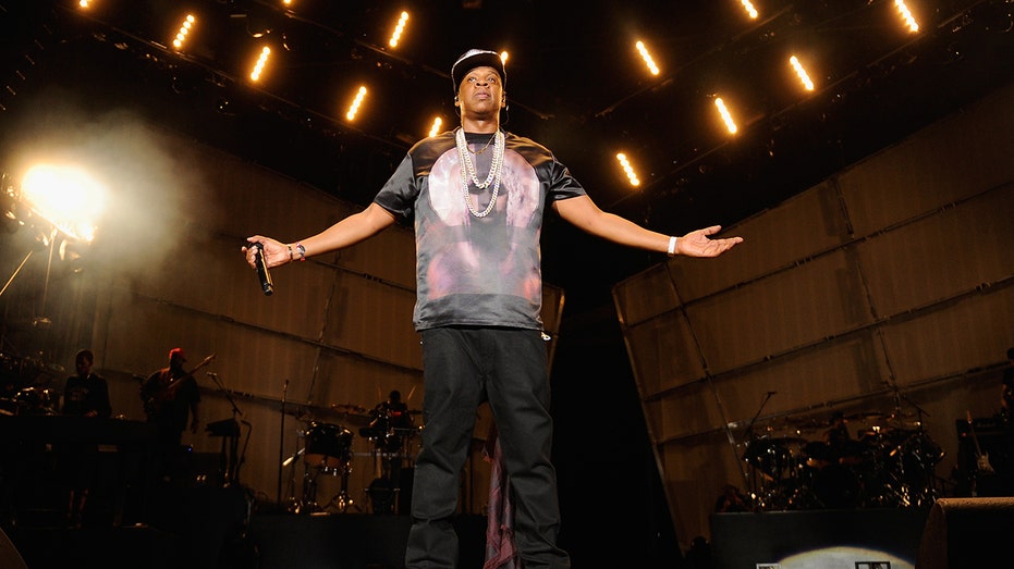 Jay Z wears diamond necklaces on stage at Made In America festival.