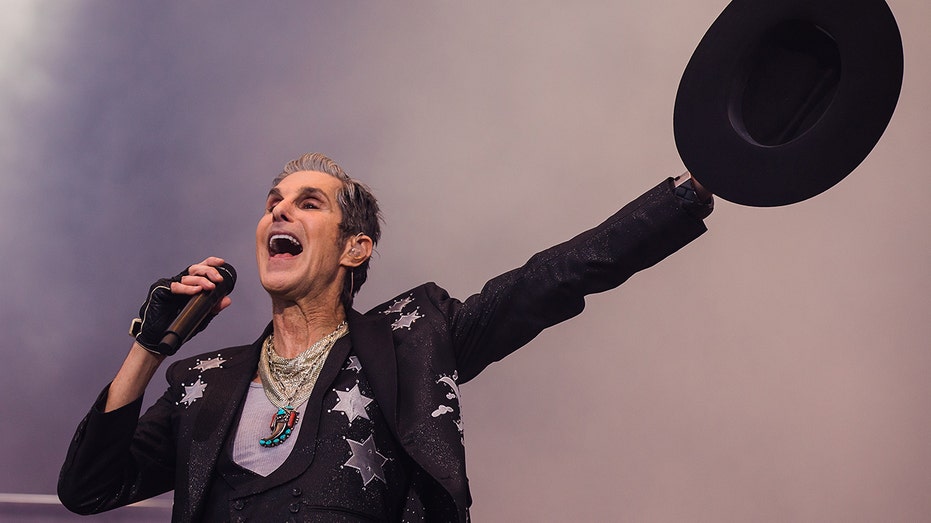 Perry Farrell throws his hat in the air while singing.