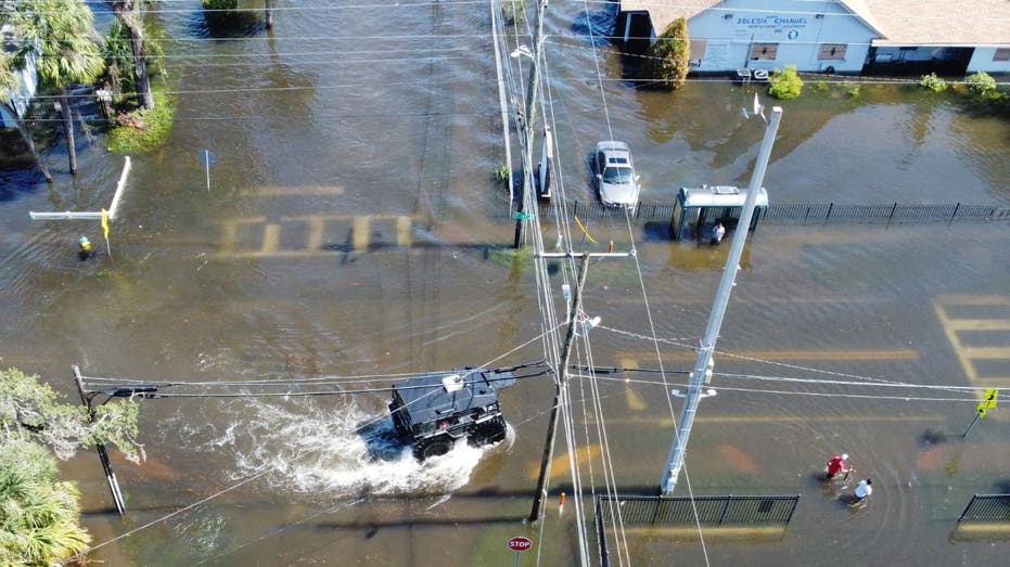 A sheriff's car drives through a flooded area in Tampa