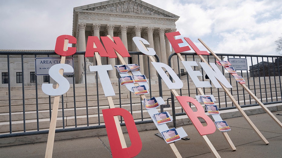 A sign calls on President Biden to cancel federal student loan debt