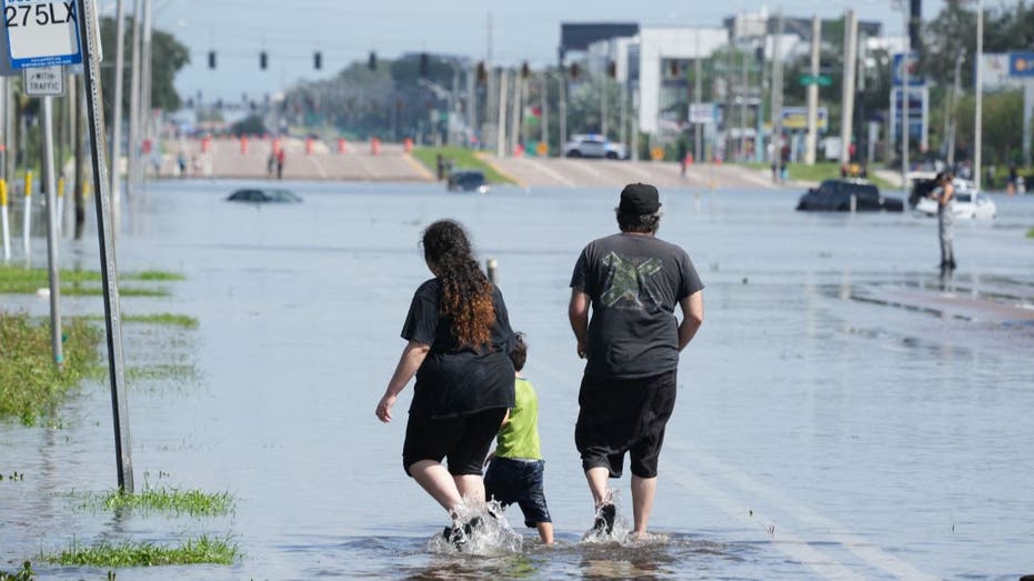 people walking in flooded Tampa street