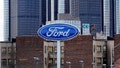 Ford Motor Co. signage is displayed outside of a dealership as the General Motors Co. (GM) headquarters building stands in the distance in Detroit, Michigan, U.S., on Monday, April 1, 2013. - Fox News
