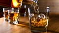 Whiskey being poured into a glass with ice. - Fox News