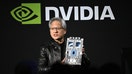 Jensen Huang, co-founder and chief executive officer of Nvidia Corp., holds up the companys AI accelerator chips for data centers.