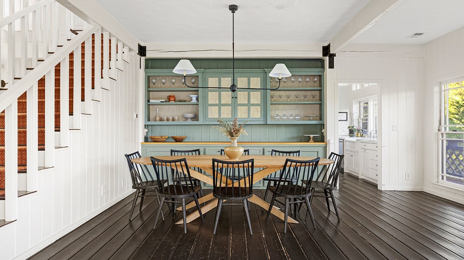 The dining room features a green accent wall with built-in shelving and cabinets.