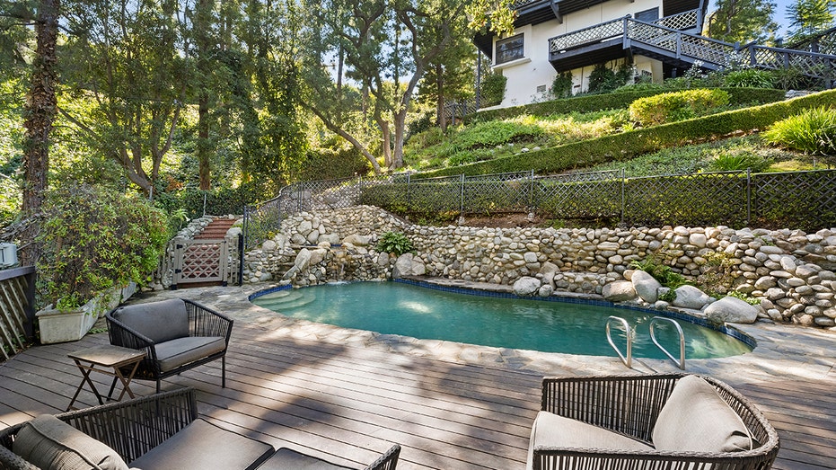 A set of stairs and a brick walkway lead to the swimming pool.