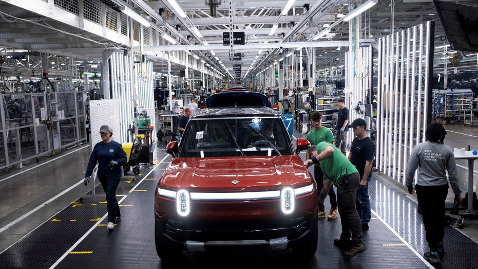 Workers assemble second-generation R1 vehicles at Rivian's manufacturing facility.