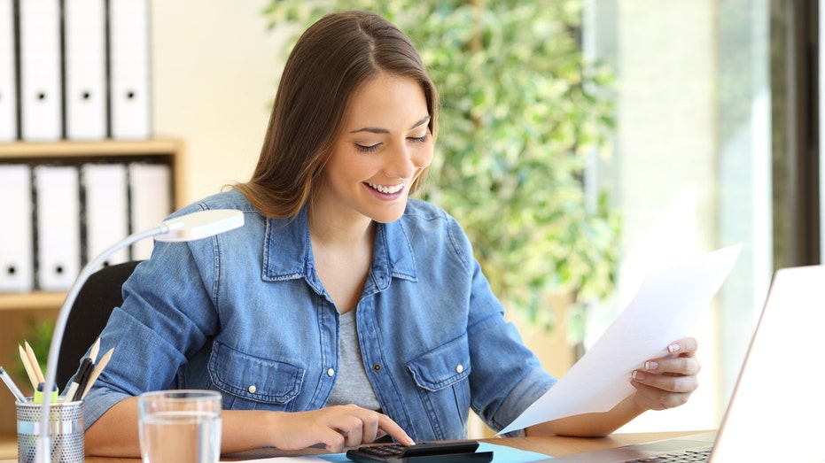 A woman calculating her finances at a desk