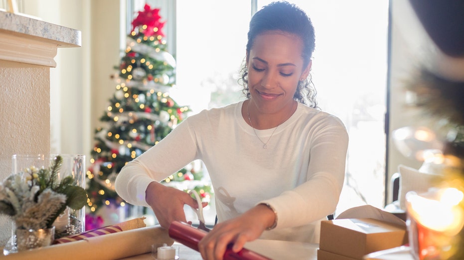 A woman cutting wrapping paper