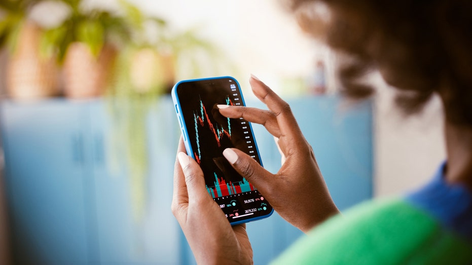 A woman watching stock market charts on phone 