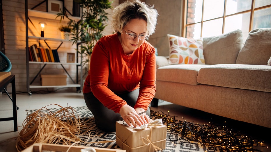 A woman wrapping Christmas gifts at home