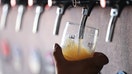 A bartender pours a beer from a tap, at Signature Brew brewery, in East London, on August 19, 2022. The brewery boom started thanks to a tax shelter that gives a 50% tax rebate to breweries that produce less than 4000 hl per year, which, combined with relatively low installation costs, has allowed the emergence of hundreds of establishments in 20 years: 1900 last year in the United Kingdom, almost 5 times more than in the early 2000s. But according to the CAMRA, an association of British craft brewers interviewed by AFP, the boom in craft breweries in the country, is already slowing down and the closing of some establishments could accelerate due to cost inflation, particularly in energy. (Photo by Hollie ADAMS / AFP) (Photo by HOLLIE ADAMS/AFP via Getty Images)