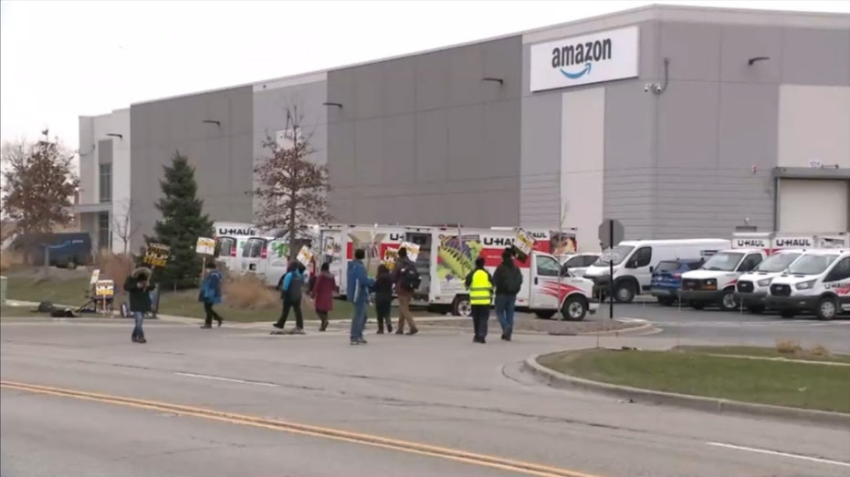 Amazon workers strike outside a warehouse building