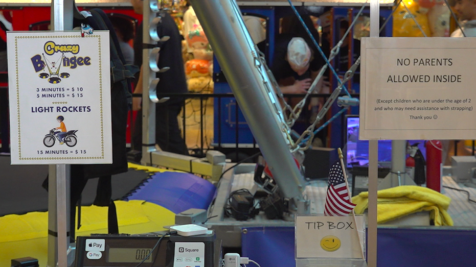 A sign lists the prices for jumping on the trampoline attraction at the mall.