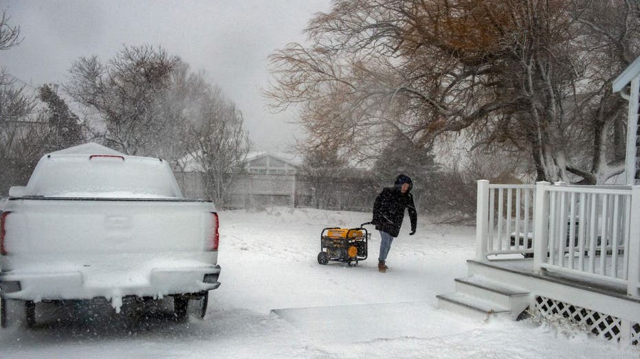 man dragging a generator to his house